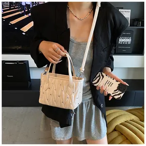 Detail of cream quilted crossbody bag with sparkling rhinestones and chain strap