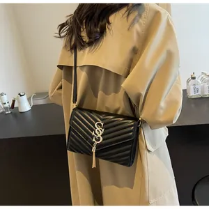 Detailansicht der schwarzen Stepptasche mit goldener Quaste und eleganter V-Förmiger Naht
