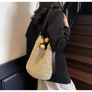 Detail of a beige woven hobo shoulder bag with a brown leather strap and tulip decor