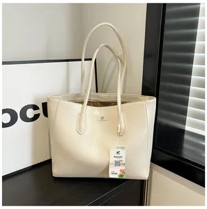 Detail view of the cream tote bag showing crinkled texture and metallic kangaroo logo