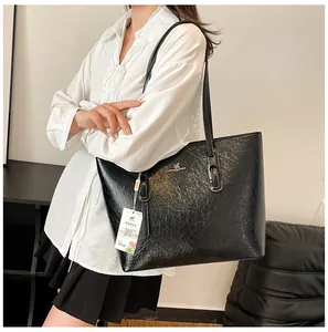 Detail der glänzenden schwarzen Tote Bag mit Silberlogo und Vintage-Lederstruktur