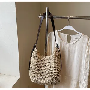 Detailed texture of straw woven bag with premium brown leather strap and metal rings