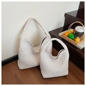 Vue détaillée de sacs cabas tissés en deux tailles avec des poignées sans couture