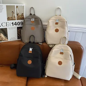 Fashionable nylon backpacks in multiple colors displayed on a luxury leather sofa