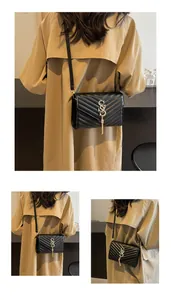 Detail der schwarzen gesteppten Umhängetasche mit goldener S-Schnalle und elegantem Quasten