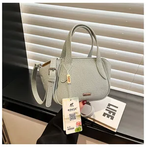 Detail der mintgrünen Handtasche aus Litschi-Leder mit verstellbarem Riemen und Metalllogo