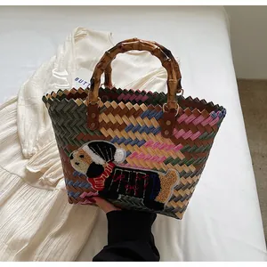 Detail of hand-woven tote bag with colorful pattern, bamboo handle and dog embroidery