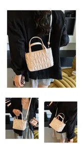 Detail of beige quilted matelassé handbag with sparkling crystals and leather strap
