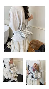 Detailed view of silver quilted matelasse handbag with metallic studs and dual handles