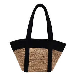 Stylish straw woven tote bag with black strap handles and contrast trim for summer