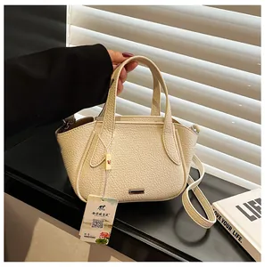 Detail der apricotfarbenen Lederstruktur auf der vielseitigen Tasche mit Metallplatte