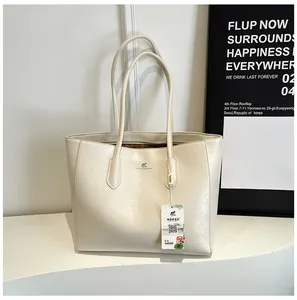 Detail of cream white tote bag featuring metallic kangaroo logo and premium leather texture