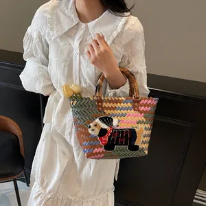 Handwoven colorful tote bag with bamboo handles and festive dachshund puppy patch