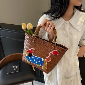 Brown woven tote bag with dachshund embroidery and natural bamboo handles in retro style