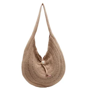 Large beige hand-woven straw tote bag with pearl button closure on white background