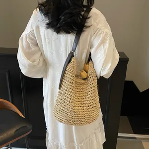 Chic woven straw shoulder bag with adjustable brown leather strap for summer beach holidays