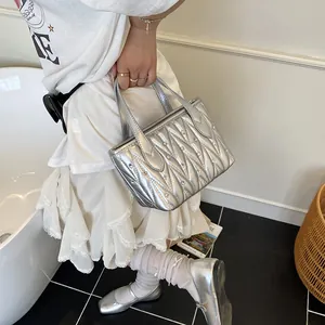 Silver quilted matelassé leather handbag with rhinestone studs and top handle