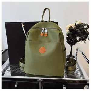 Detail of sage green nylon backpack with leather logo on a metal cart and urban decor
