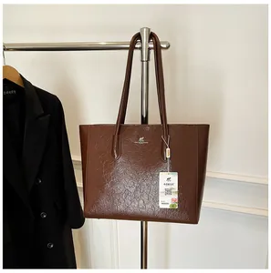 Detail of vintage brown tote bag showing glossy wrinkled leather and kangaroo emblem