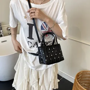 Quilted black crossbody bag with silver rhinestones shown in a stylish lifestyle scene