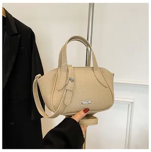 Detailaufnahme der beigen Lederstruktur und der silbernen Beschläge der kleinen Handtasche
