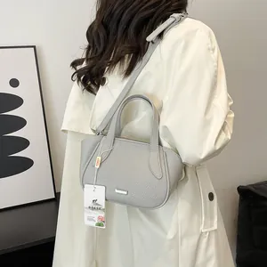 Hellgraue Handtasche für Damen aus genarbtem Leder mit Trageriemen und seitlichen Falten