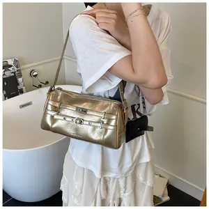 Detailaufnahme der goldenen Baguette-Tasche mit Y2K-Schnalle und metallischer Textur