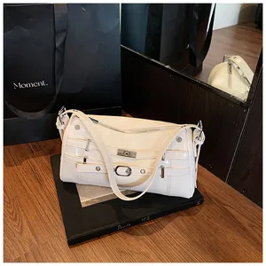 Detailaufnahme der beigen Glanzlacktasche mit Y2K-Schnallen und Metallnieten-Design