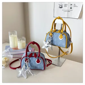 Detail of mini denim boston bags in red and yellow with cute silver star charms