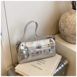 Nahaufnahme einer silbernen Metallic-Schultertasche mit Schnallenriemen und Drehverschluss
