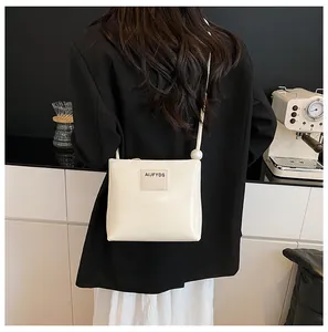 Borsa a tracolla squadrata bianco crema minimalista con patch logo cucito e sfera decorativa
