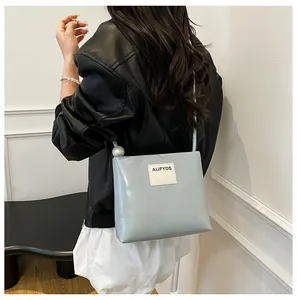 Dettaglio borsa lucida azzurra con decoro di perle e applicazione in pelle AIJFYDS