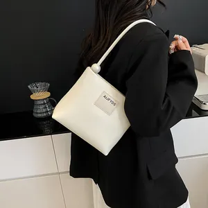 Borsa quadrata in pelle bianca minimalista con manico di perle e tracolla regolabile