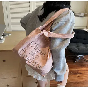 Dettaglio della borsa tote in tela rosa con ricamo Chase My Dreams per uso quotidiano