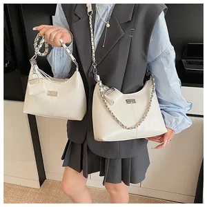 Detail van witte PU-lederen hobo tas met zilveren ketting en kleine hanger tas