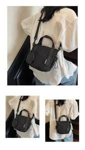 Close-up of black nylon crossbody bag with mini coin purse and adjustable strap