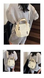 Detail of cream nylon crossbody bag with side drawstring and detachable round coin purse