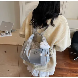 Silver metallic tote with puffy cloud charm shown on model in a minimalist home setting