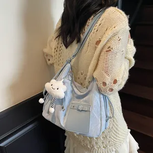 Light blue large capacity tote bag with white cloud plush charm on a female model