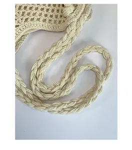 Close-up of thick woven shoulder strap and hollow-out cotton crochet texture on beach bag