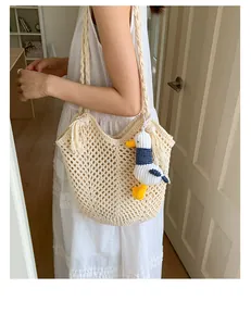 Detail of hollow woven cotton tote bag with tassel and plush seagull charm