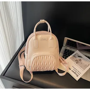 Detail of light pink mini bag with mesh texture and pleated pocket on a desk