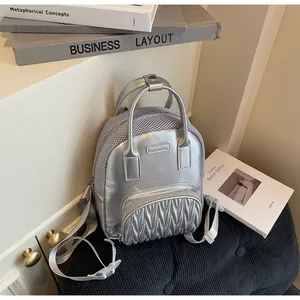 Detail of silver metallic bag with wave pleated front pocket and mesh fabric stitching