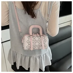 Detail of a white leather Boston bag with silver studs and pink trim on a female model