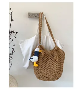 Detail of woven tote bag with openwork crochet design and cute duck charm