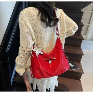 Detail of red oversized hobo bag featuring a decorative bow and sparkling star charm