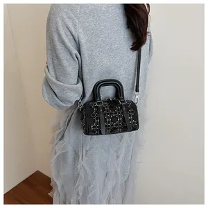 Detail of black mini Boston bag with silver studs in cannage pattern on leather