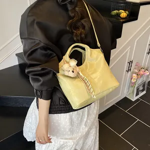 Borsa a secchiello minimalista grande in pelle coccodrillo con ciondolo a forma di orsetto