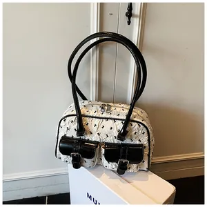 Detail view of the lace-textured handbag with black leather trim and double front pockets
