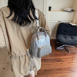 Silver metallic mini backpack featuring quilted folds and mesh details in a modern city style